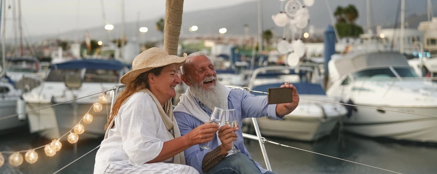 A senior couple toasting with champagne on a sailboat — the getaway you could win